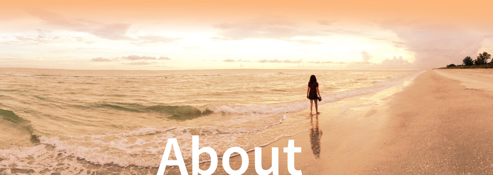Banner image for About page, beautiful sunset scene at the beach, orange glow, my wife Rachel strolling down the shoreline, looking out on the horizon.
